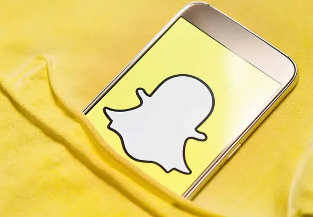 A phone showing the Snapchat logo.